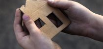 homeless boy holding a cardboard house, dirty hand